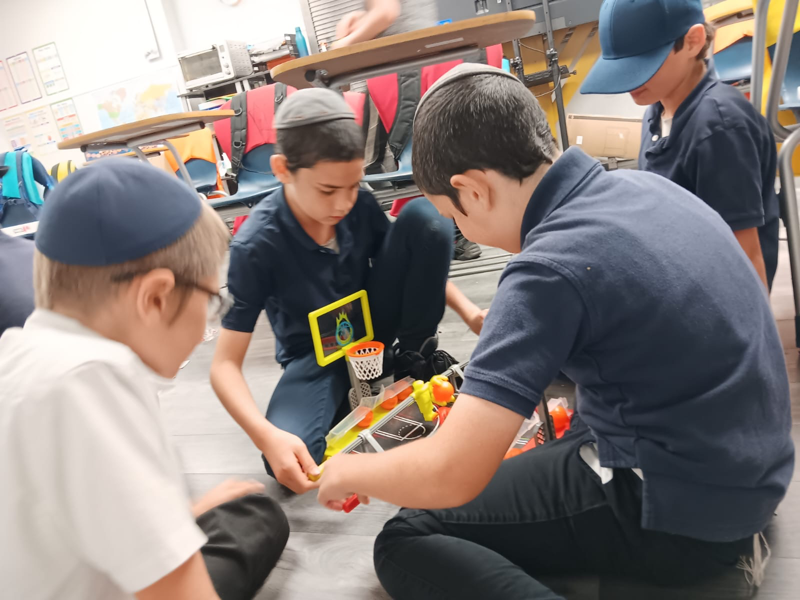 Boys building a project together on the classroom floor
